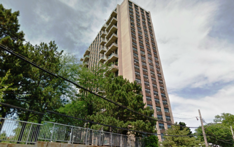 High-rise apartment tower under blue sky